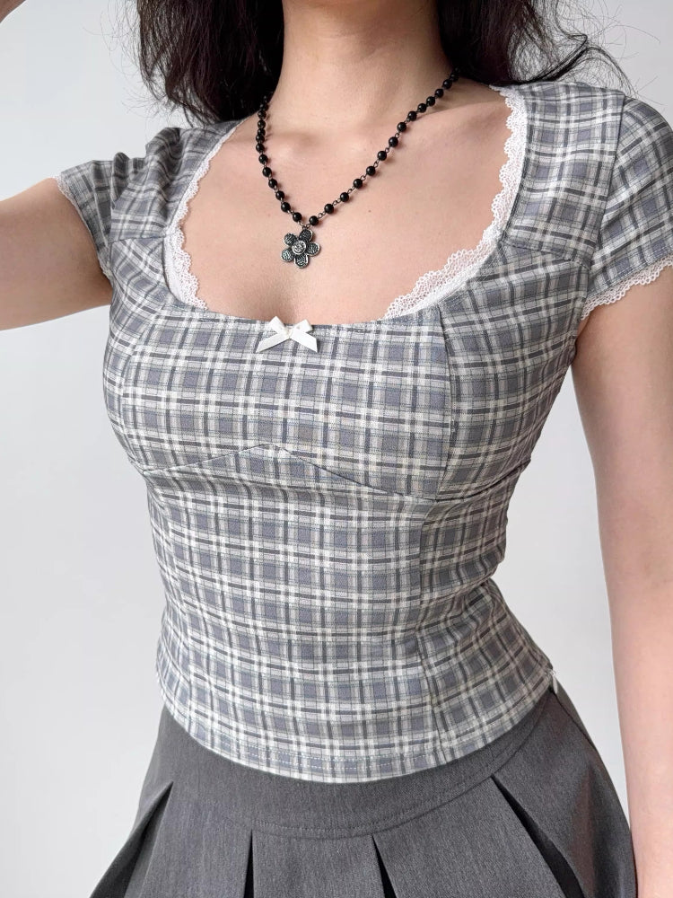 Grey plaid fitted short sleeve top with white lace trim and a small white bow detail at the neckline.