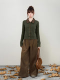 Side profile of the dark green cable knit cardigan showcasing its collar and buttons.