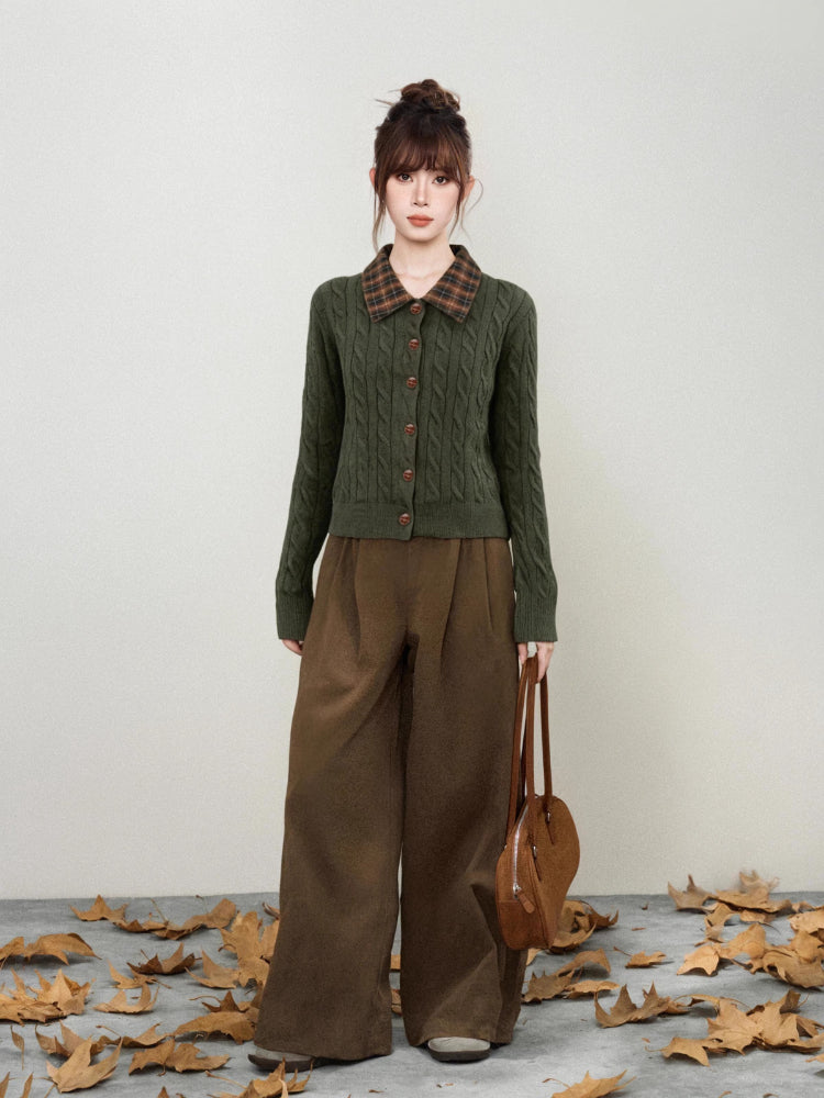 Side profile of the dark green cable knit cardigan showcasing its collar and buttons.