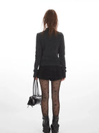 Back view of a woman wearing a dark grey knit cardigan.