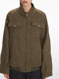 Front view of a woman wearing a brown herringbone bomber jacket.