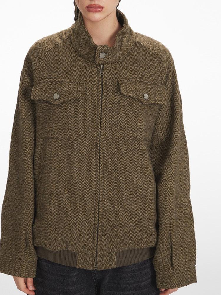 Front view of a woman wearing a brown herringbone bomber jacket.