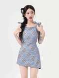 Woman wearing a blue plaid mini dress with tie shoulder straps