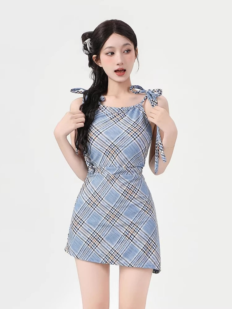 Woman wearing a blue plaid mini dress with tie shoulder straps