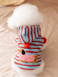 Back view of a dog wearing a blue and red striped hooded dog coat with a dachshund appliqué.