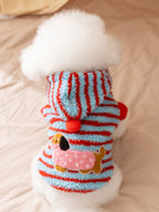 Back view of a dog wearing a blue and red striped hooded dog coat with a dachshund appliqué.
