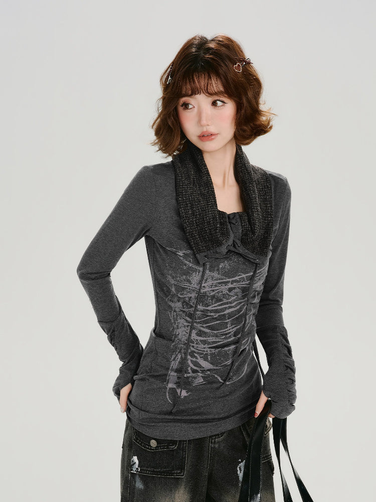 Woman wearing a dark gray long-sleeve fitted top with a graphic print and a removable knit scarf collar.
