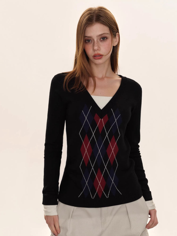 Woman wearing a black argyle V-neck sweater with a white undershirt and beige cargo pants.