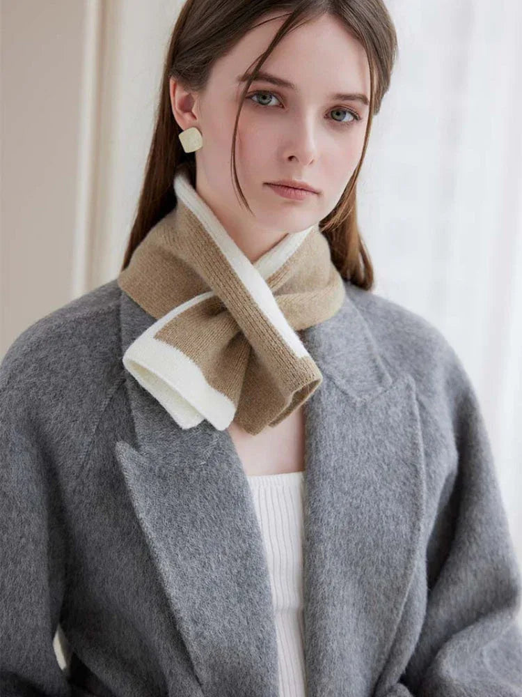 Close-up of a woman's neck and shoulders wearing a beige and white striped knit scarf