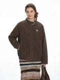 Woman posing with a brown corduroy bomber jacket and a shoulder bag