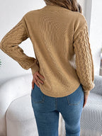Back view of a woman in a tan textured knit sweater, showcasing the knit detail on the sleeves.