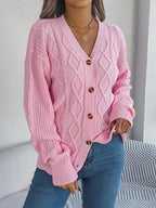 Close-up of the front of a pink cable knit cardigan on a woman