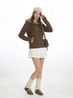Full body shot of a woman in a brown cardigan, white skirt, and leg warmers.