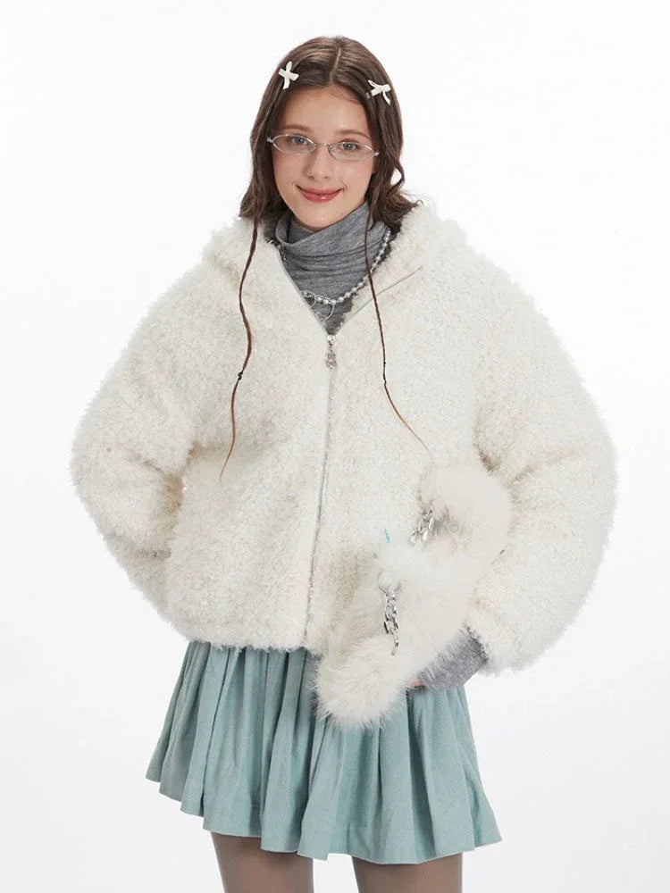 Close-up front view of a woman wearing a white fuzzy fleece hooded jacket with bunny ears and a silver zipper.