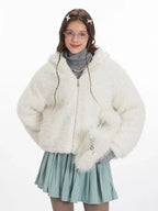 Close-up front view of a woman wearing a white fuzzy fleece hooded jacket with bunny ears and a silver zipper.