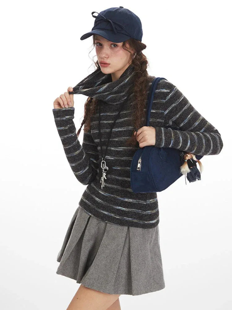 Close-up of a model adjusting her turtleneck sweater, showcasing the striped pattern and the pleated skirt.