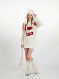 Close-up of the cream knit sweater with off-the-shoulder detail and a red and white striped scarf with stars.