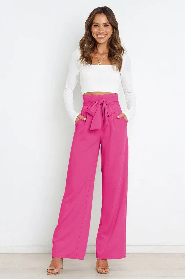 woman wearing pink wide leg tie waist pants with a white long sleeve crop top Main image