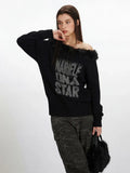 Side profile of a woman showcasing the off-the-shoulder design of a black knit sweater with faux fur trim and a graphic print.