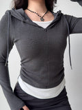 Front view of a charcoal grey long-sleeved hoodie featuring a zip closure and a hood, styled casually.