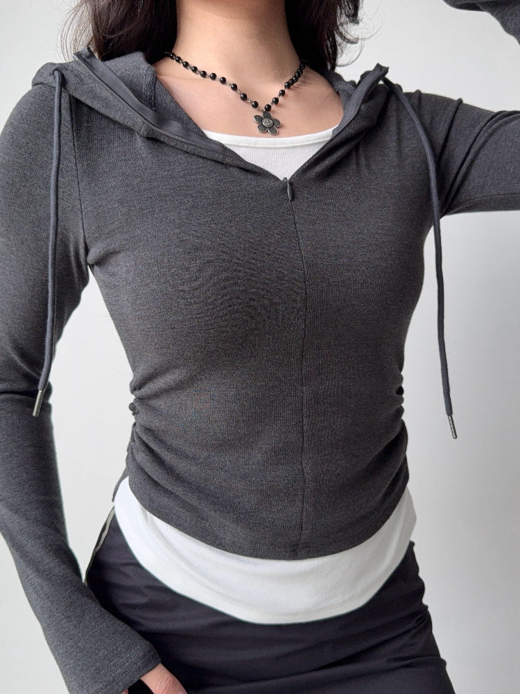 Front view of a charcoal grey long-sleeved hoodie featuring a zip closure and a hood, styled casually.