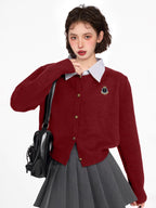 Woman wearing a burgundy knit cardigan with a collared neckline and button-up front, paired with a grey pleated skirt.