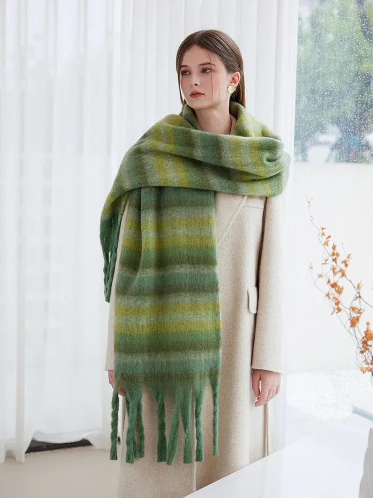 Woman wearing an oversized green striped scarf with fringe detail