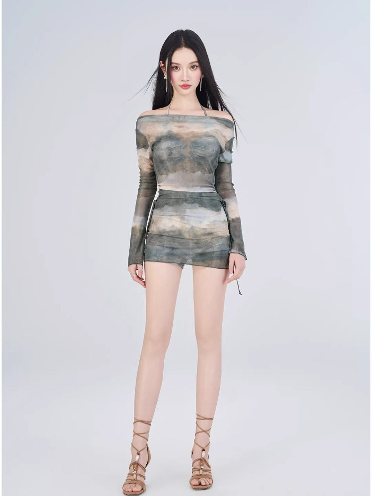Full body shot of a woman in a printed mesh top and skirt ensemble.