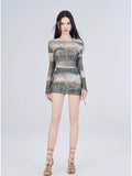 Full body shot of a woman in a printed mesh top and skirt ensemble.