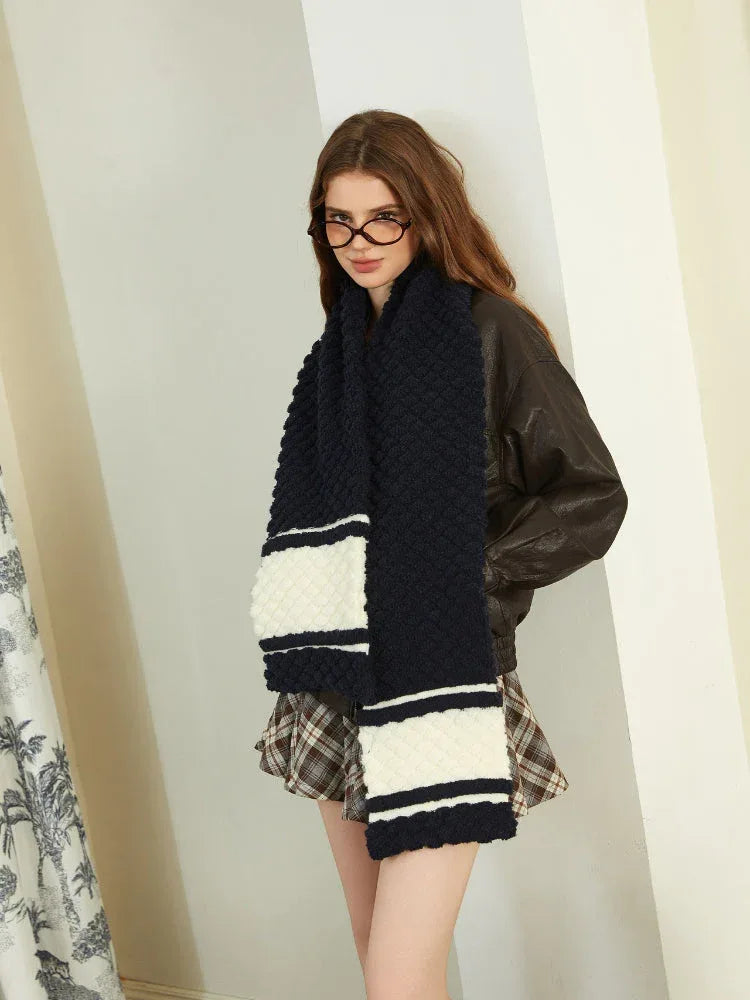 Close-up of a woman wearing a navy and white striped knit scarf.