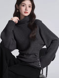 Detail shot of the turtleneck on a dark grey knit sweater