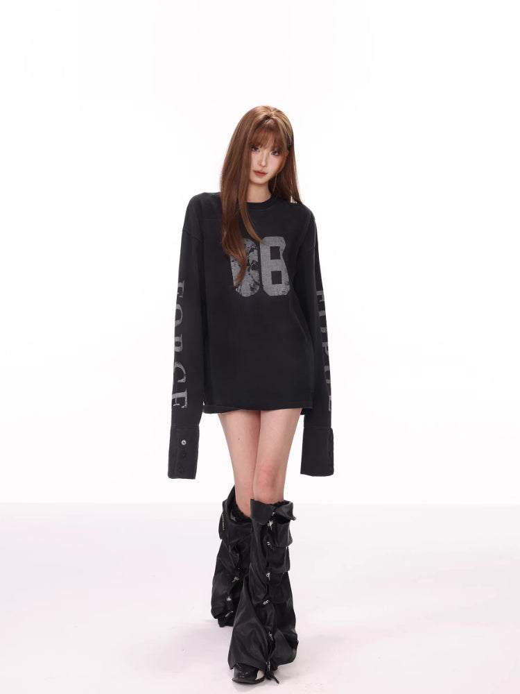 Full-body shot of a model in a black long-sleeve graphic t-shirt and edgy boots.