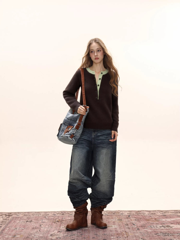 Woman wearing a brown long-sleeved knit sweater with a light green contrast neckline and button-up placket, paired with distressed denim jeans.