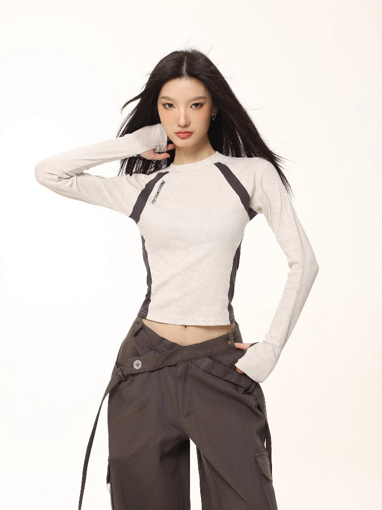 Model wearing a light grey long-sleeve athletic top with dark grey contrasting panels.