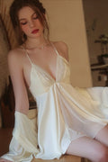 Side profile of a woman wearing a cream satin chemise and robe, highlighting the flowing fabric.