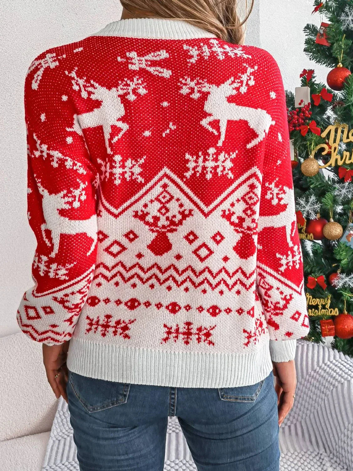 Back view of a woman wearing a red and white festive knit sweater.