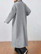 Rear view of a woman wearing a grey longline wool blend coat.