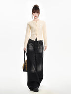 Woman modeling a cream cable knit cropped cardigan, dark wash wide-leg jeans, and a handbag with a faux fur accent.