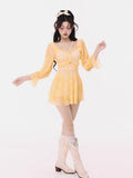 Woman posing in a yellow tie-dye mini dress.