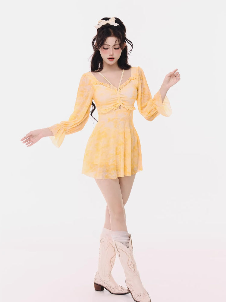 Woman posing in a yellow tie-dye mini dress.