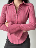 Woman with arms crossed wearing a pink striped collared shirt.