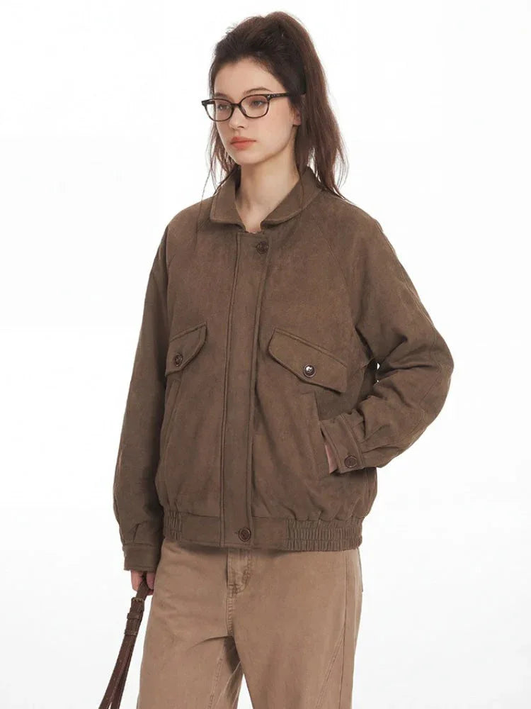 Close-up of a woman's torso wearing a brown textured bomber jacket with elasticized cuffs and waistband.