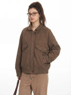 Close-up of a woman's torso wearing a brown textured bomber jacket with elasticized cuffs and waistband.