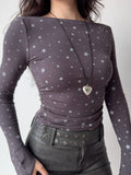 Front view of a woman in a grey star-print top and a black leather mini skirt.