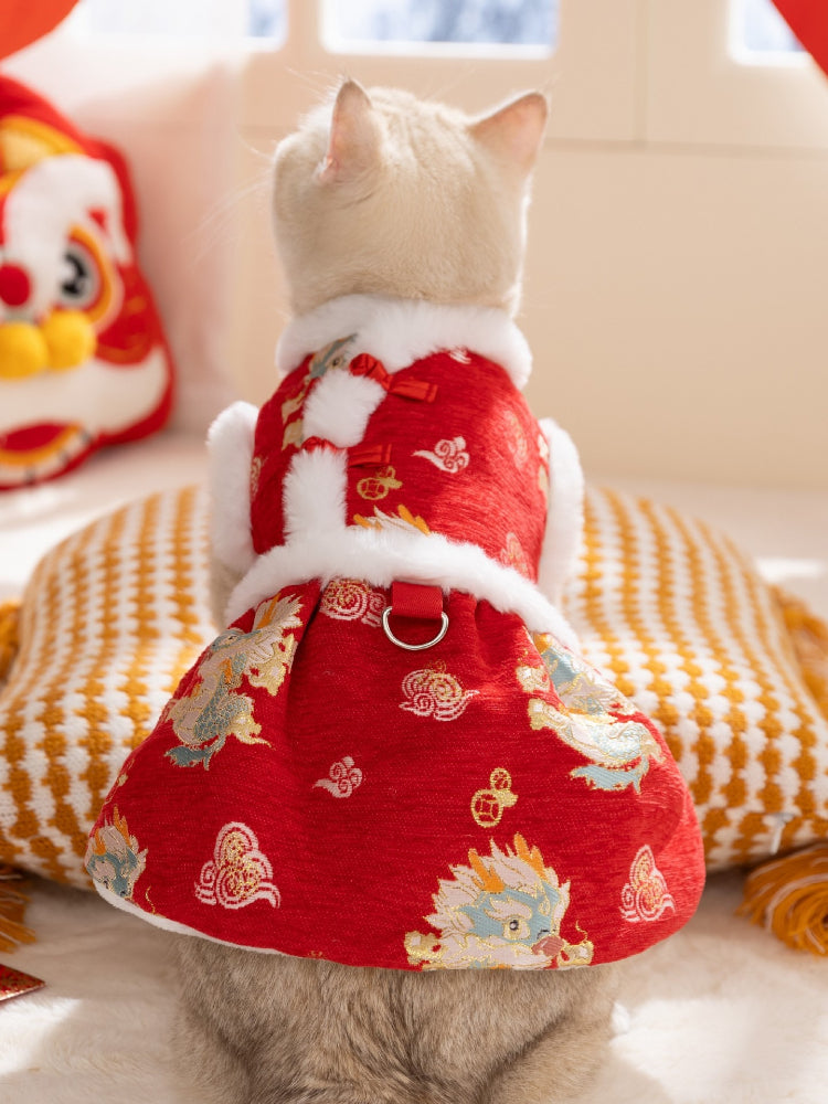 Cat wearing a red festive vest dress with traditional Chinese patterns and white faux fur trim