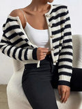 Woman wearing a black and white striped knit cardigan with pearlized buttons