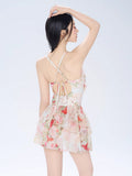 Back view of a floral print tiered dress showing criss-cross straps and a cutout detail.
