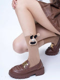 Tan crew socks with a cow applique and pom-poms