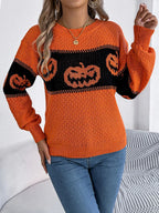 Model posing in a festive orange pumpkin patch knit sweater.