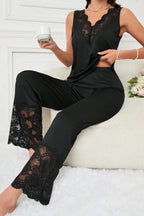 Woman wearing a black sleeveless pajama top and wide-leg pants with lace trim, holding a cup.